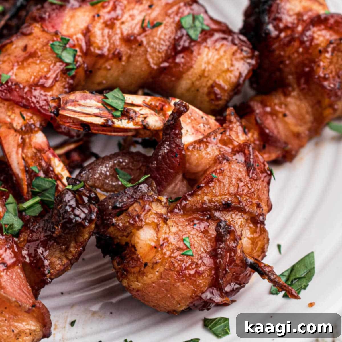 Smoked bacon wrapped shrimp on a plate, with a toothpick holding together.