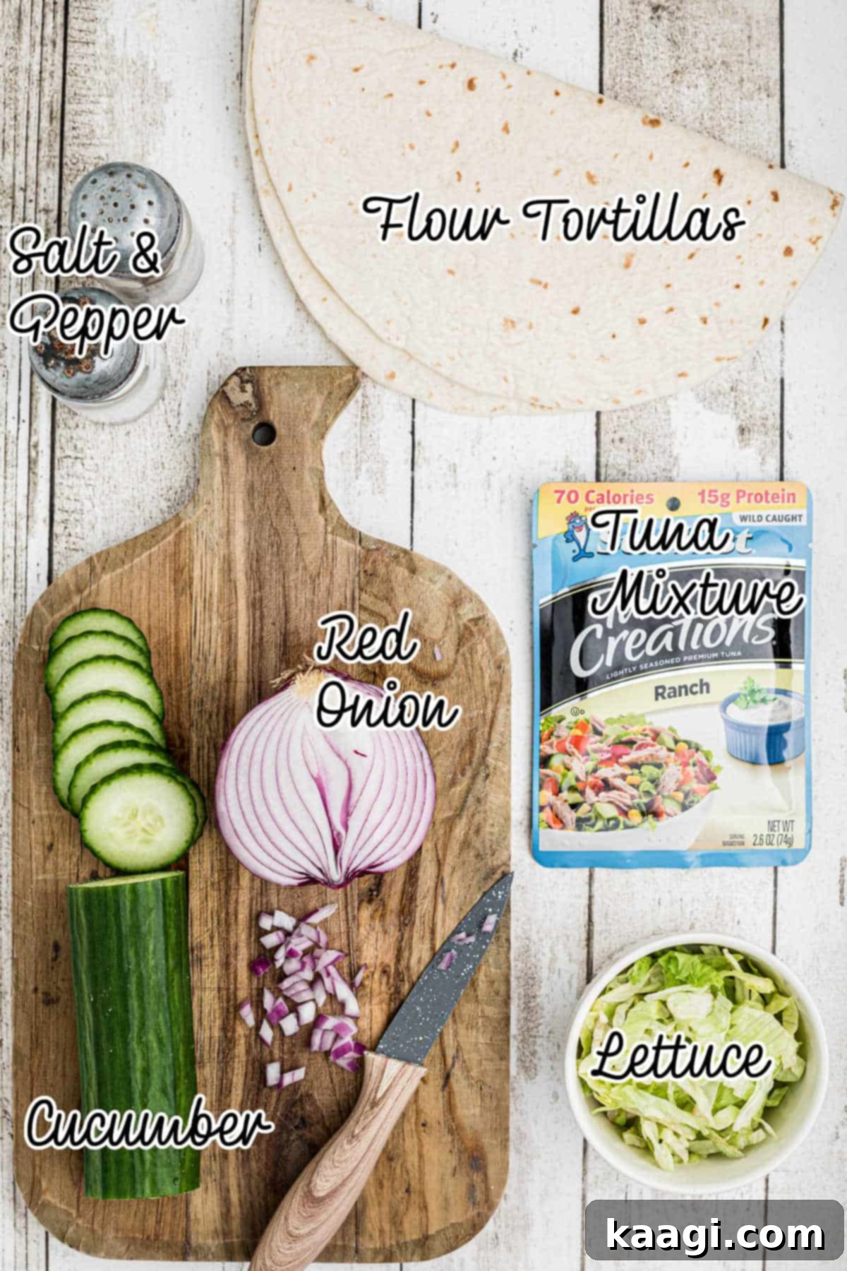 A flat lay image displaying all the fresh ingredients needed to prepare tuna pinwheels, including tortillas, tuna pouches, cucumber, red onion, and lettuce.