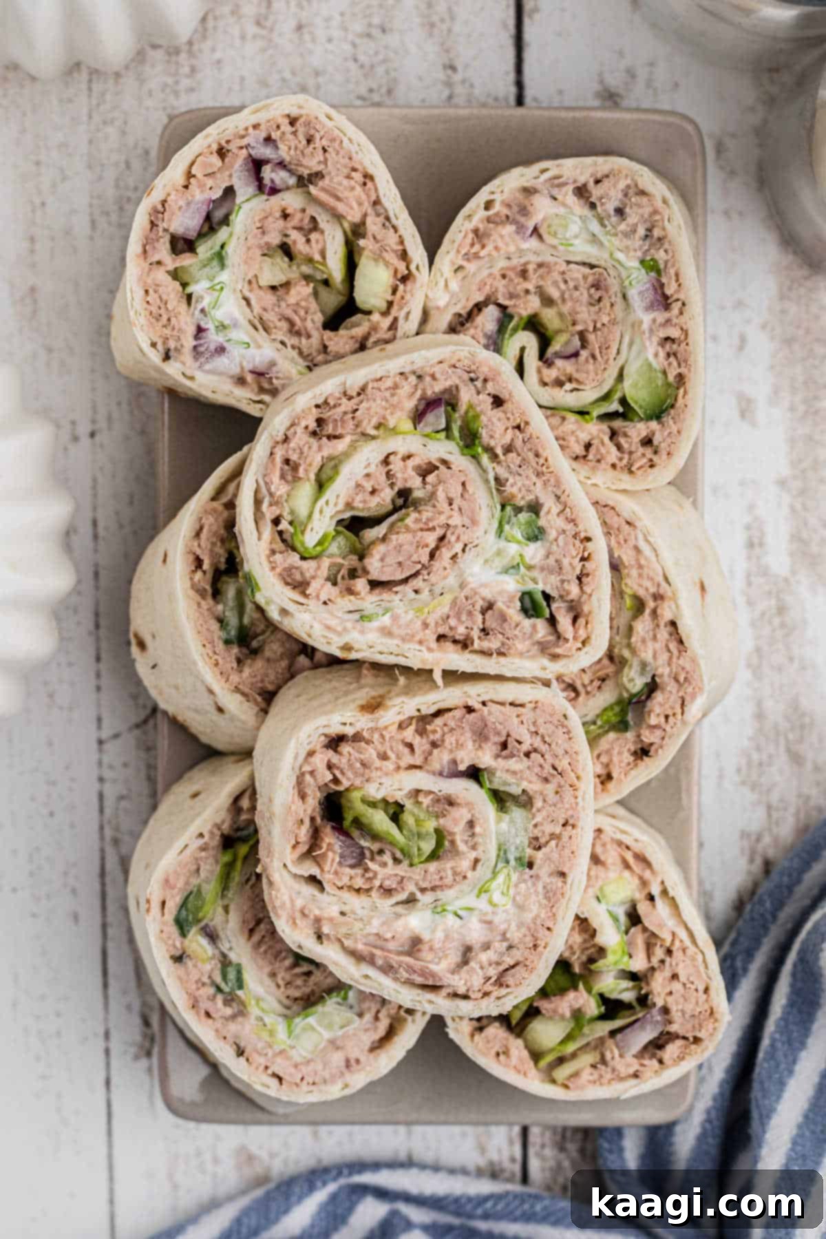Overhead, long shot of a small plate filled with various tuna salad pinwheels, showcasing different fillings.