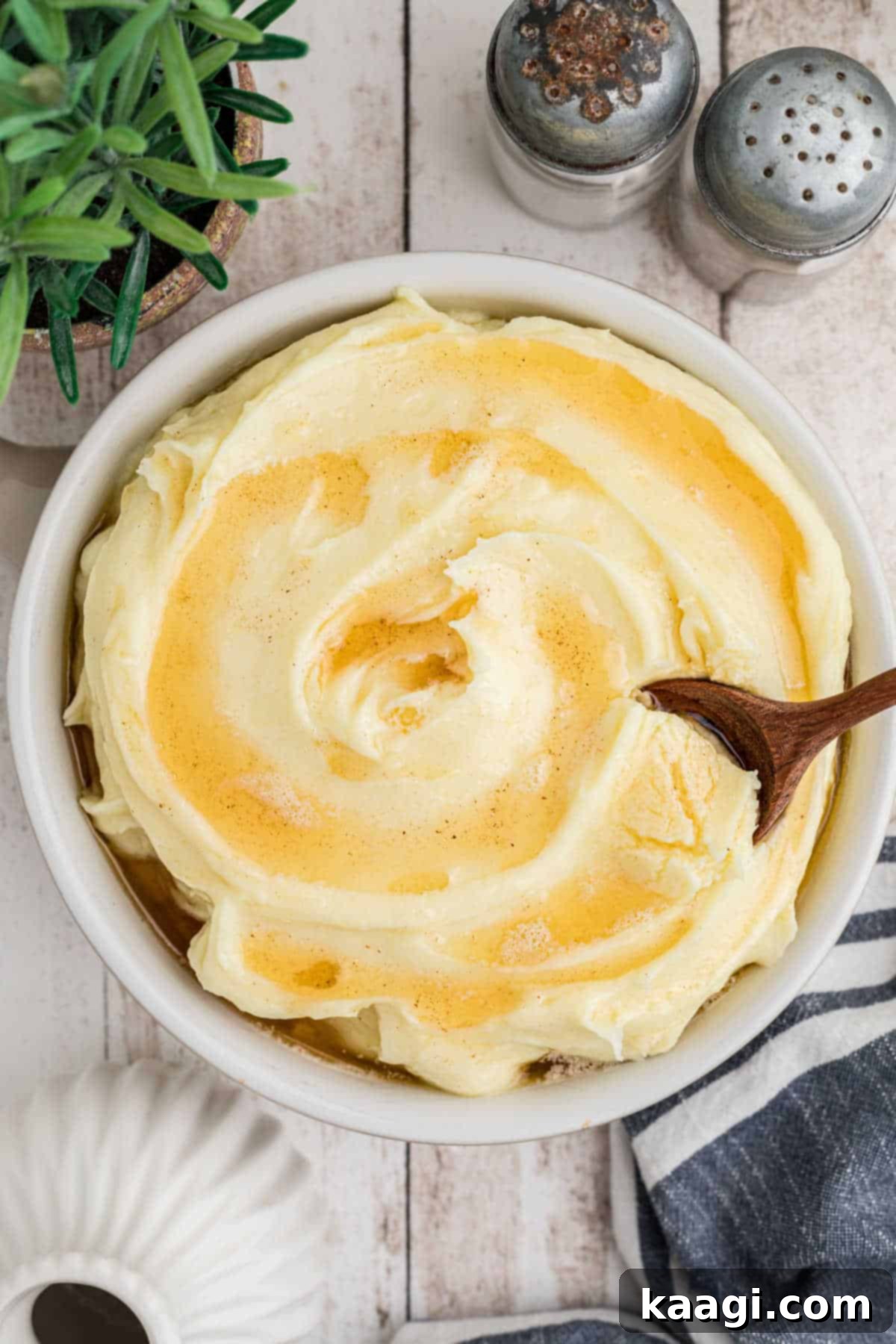 Amish Farmhouse Mashed Potatoes 4 Overhead view of a bowl of amish mashed potatoes with a spoon digging in, showing the creamy texture.