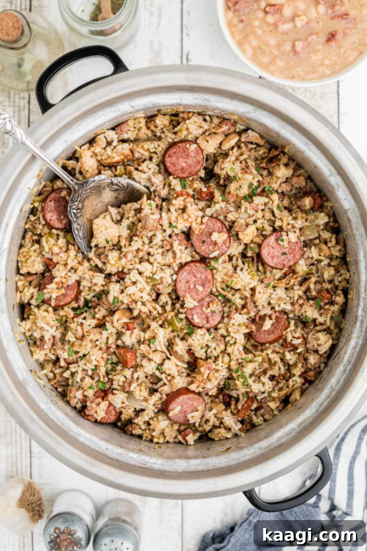 Overhead shot of a rice cooker with jambalaya and a spoon digging in.