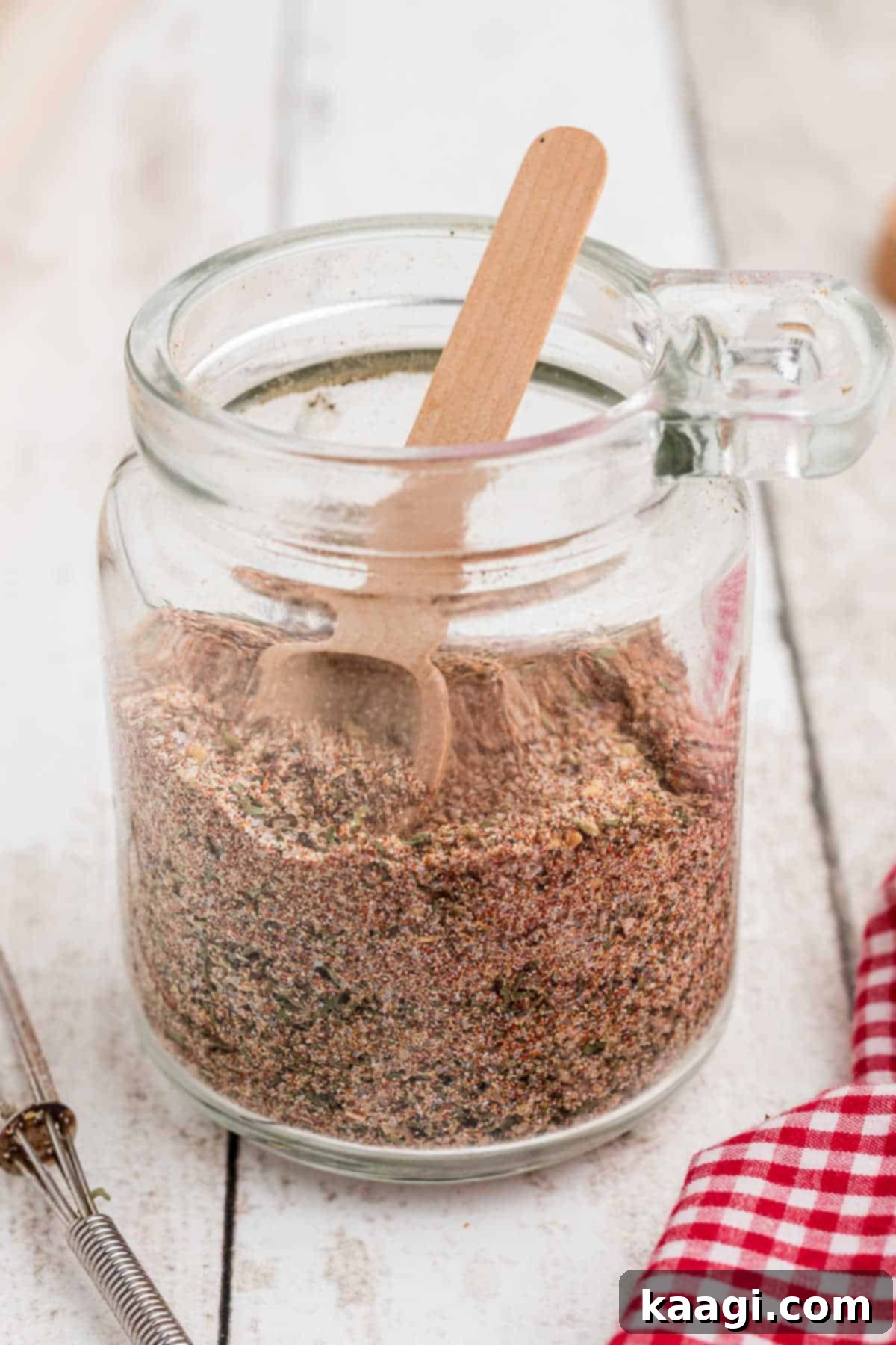 Side angle shot of a glass container filled with all purpose seasoning.