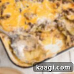 Homestyle Beef and Potato Casserole 15 A perfectly squared image of a hearty hamburger potato casserole with a spoon, showing a delicious serving removed.