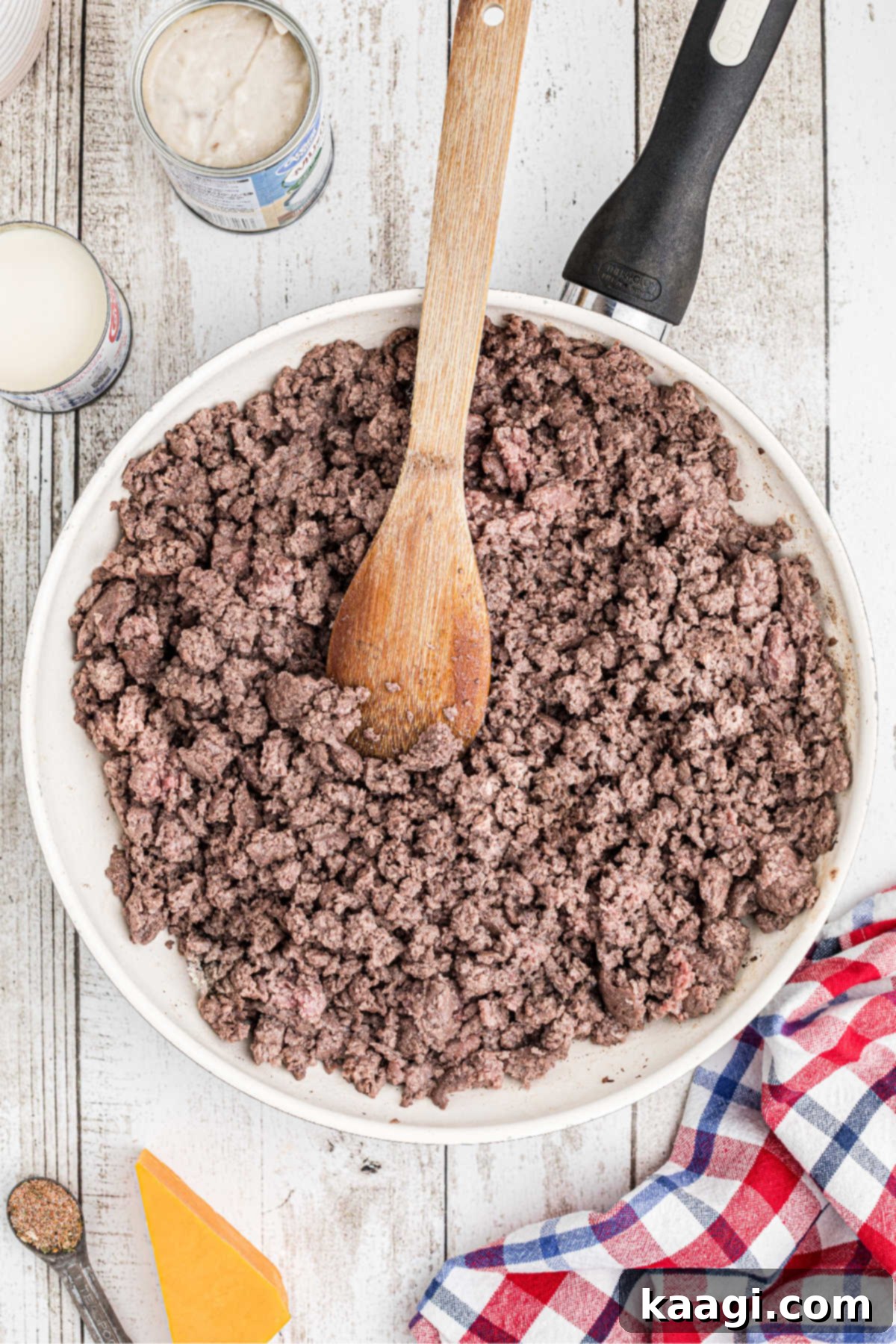 Homestyle Beef and Potato Casserole 4 Ground beef sizzling and browning in a large, hot skillet on a stovetop, ready to be incorporated into the casserole.