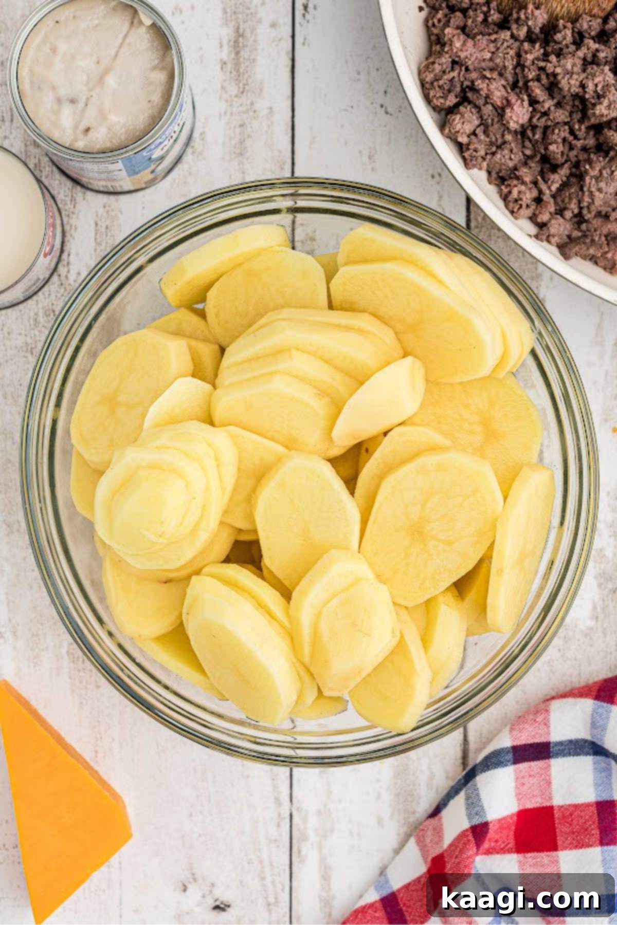 Homestyle Beef and Potato Casserole 5 Thinly sliced potatoes, perfectly uniform, gathered in a large mixing bowl, prepared for layering.