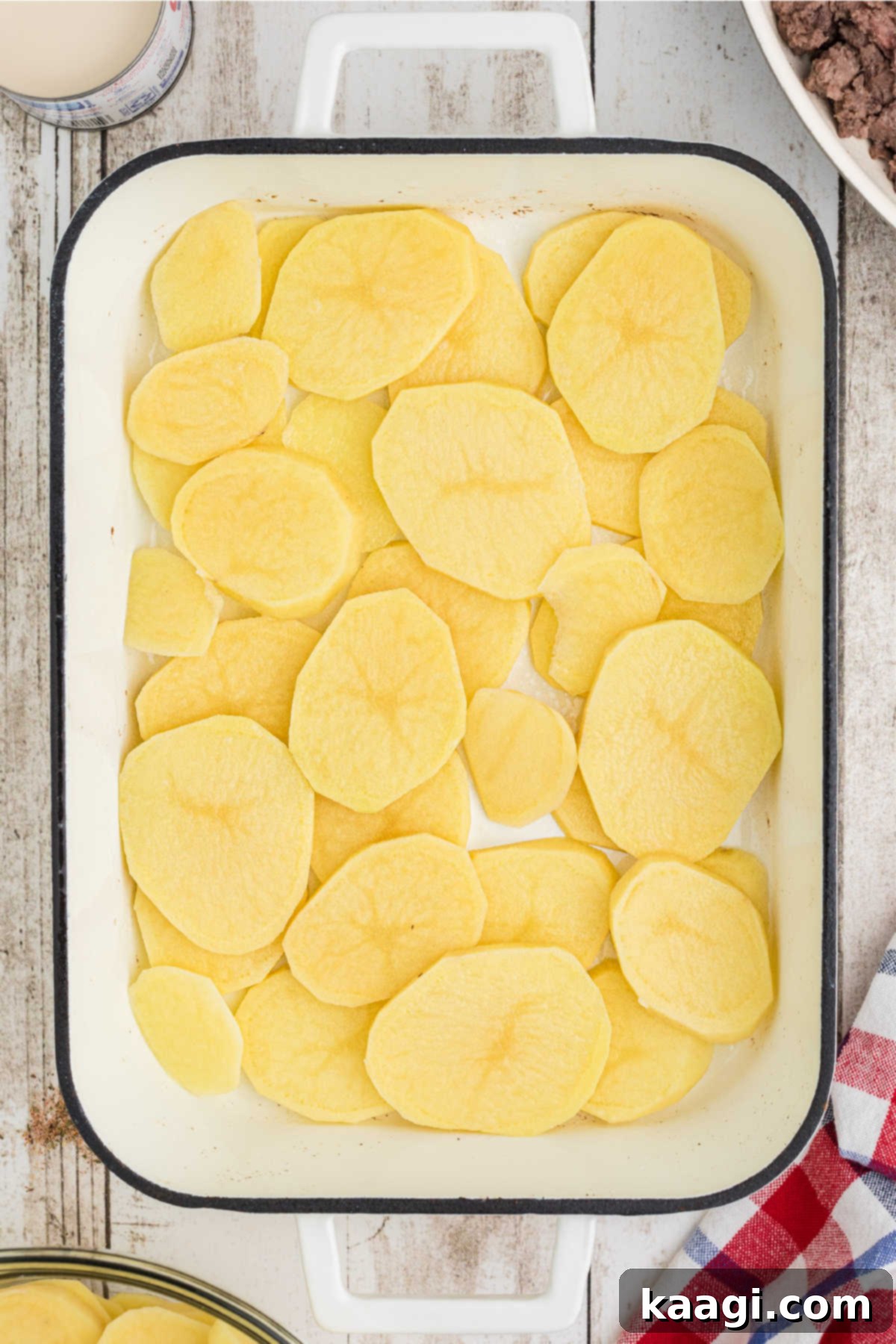 Homestyle Beef and Potato Casserole 6 A pristine layer of thinly sliced potatoes forming the base in a well-greased 13x9 inch baking dish.