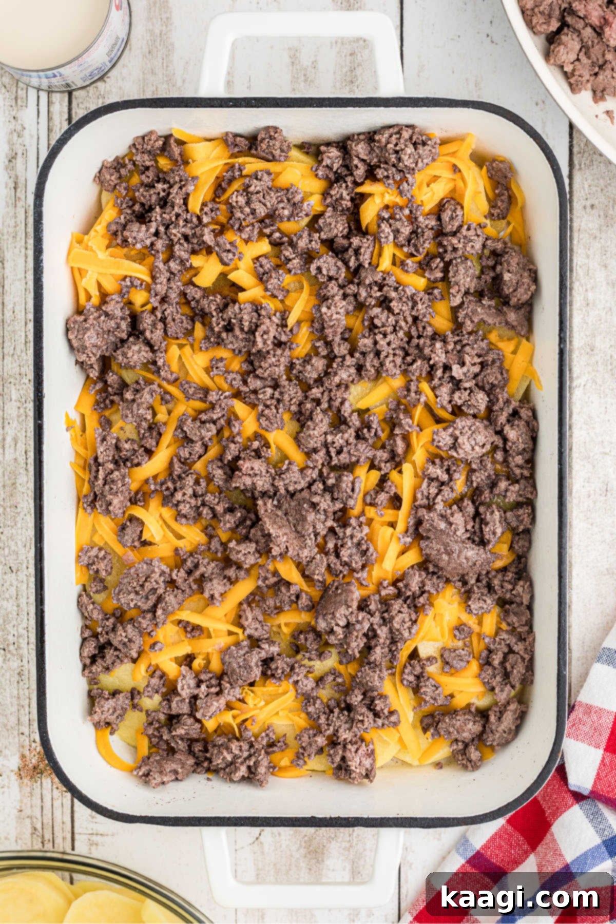Homestyle Beef and Potato Casserole 8 Crumbled, browned ground beef evenly scattered over the cheese and potato layers in the baking dish.