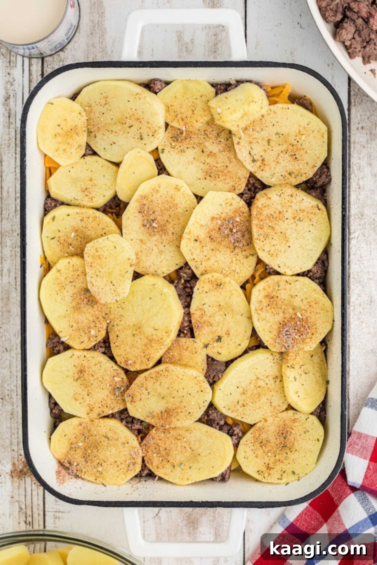Homestyle Beef and Potato Casserole 9 Subsequent layers of potatoes, cheese, and ground beef neatly stacked within the baking dish, building the casserole.