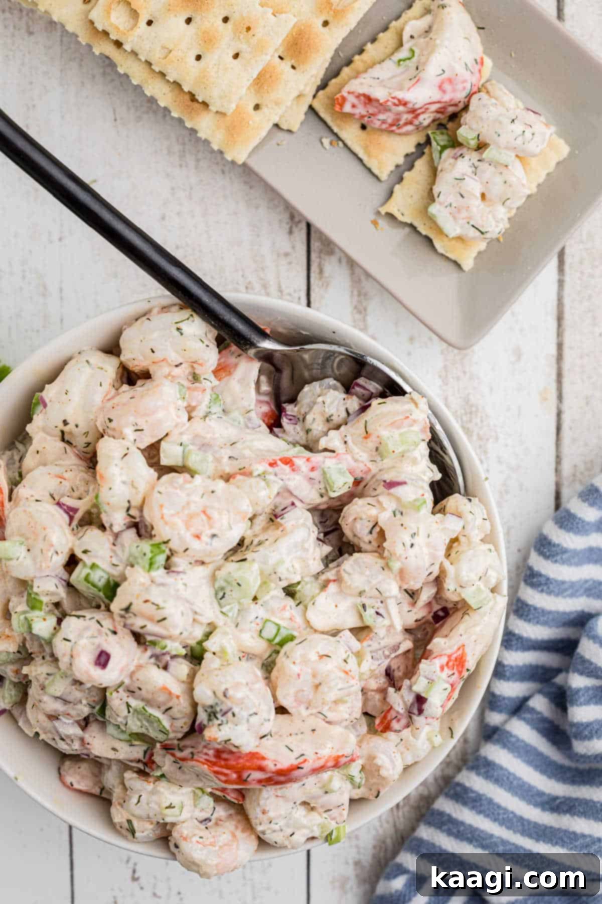 Deep South Seafood Symphony 10 A bowl of seafood salad with a spoon and some crackers.