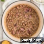 Overhead shot of a pot of pinto beans, cropped square, indicating a finished dish, rich and ready to serve.