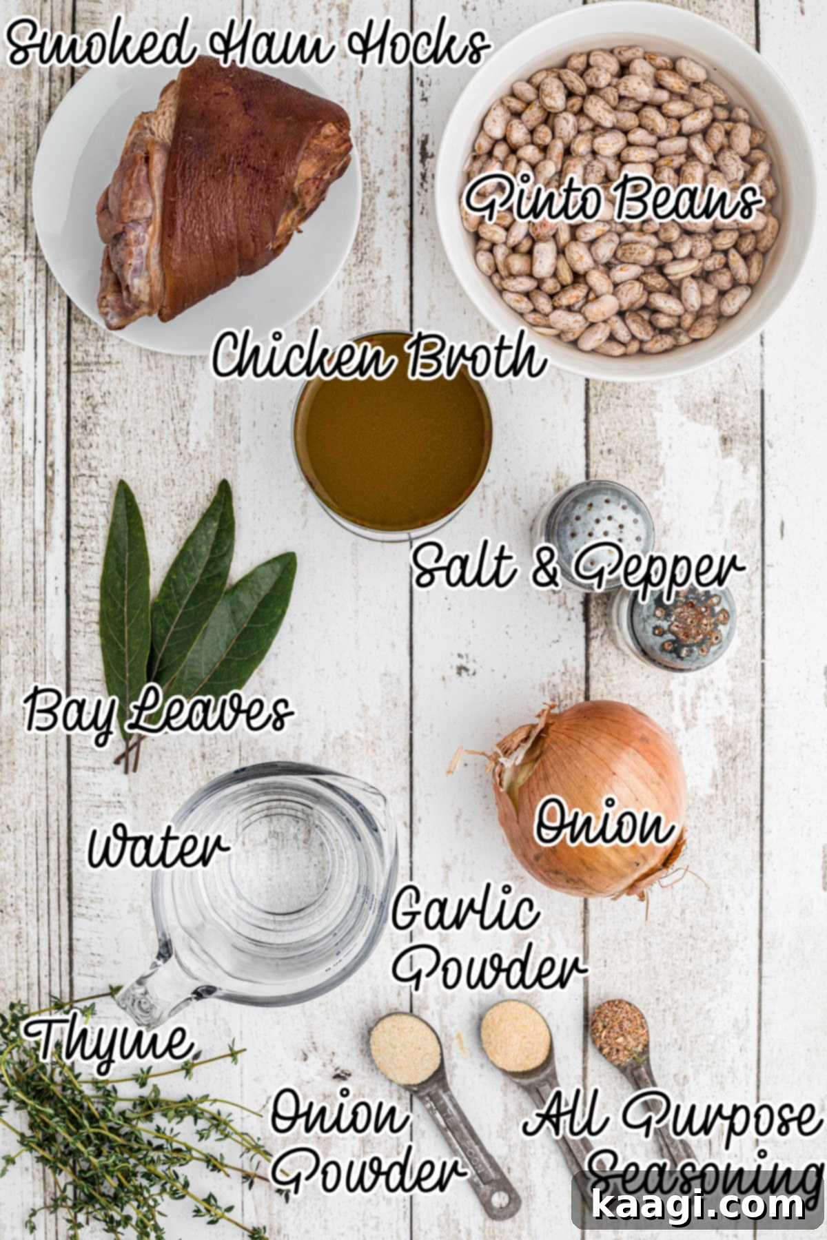 Overhead shot of the fresh ingredients needed for a pinto beans recipe, including dried beans, ham hocks, onion, and spices arranged on a surface.
