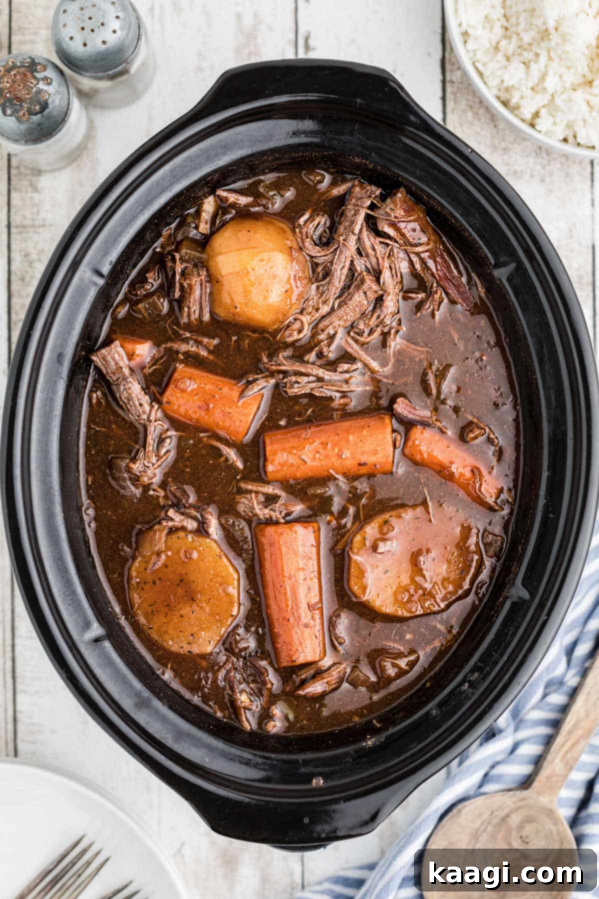 Red Wine Braised Venison Pot Roast 2 Overhead shot of a slow cooker full of venison roast with red wine and carrots and potatoes.