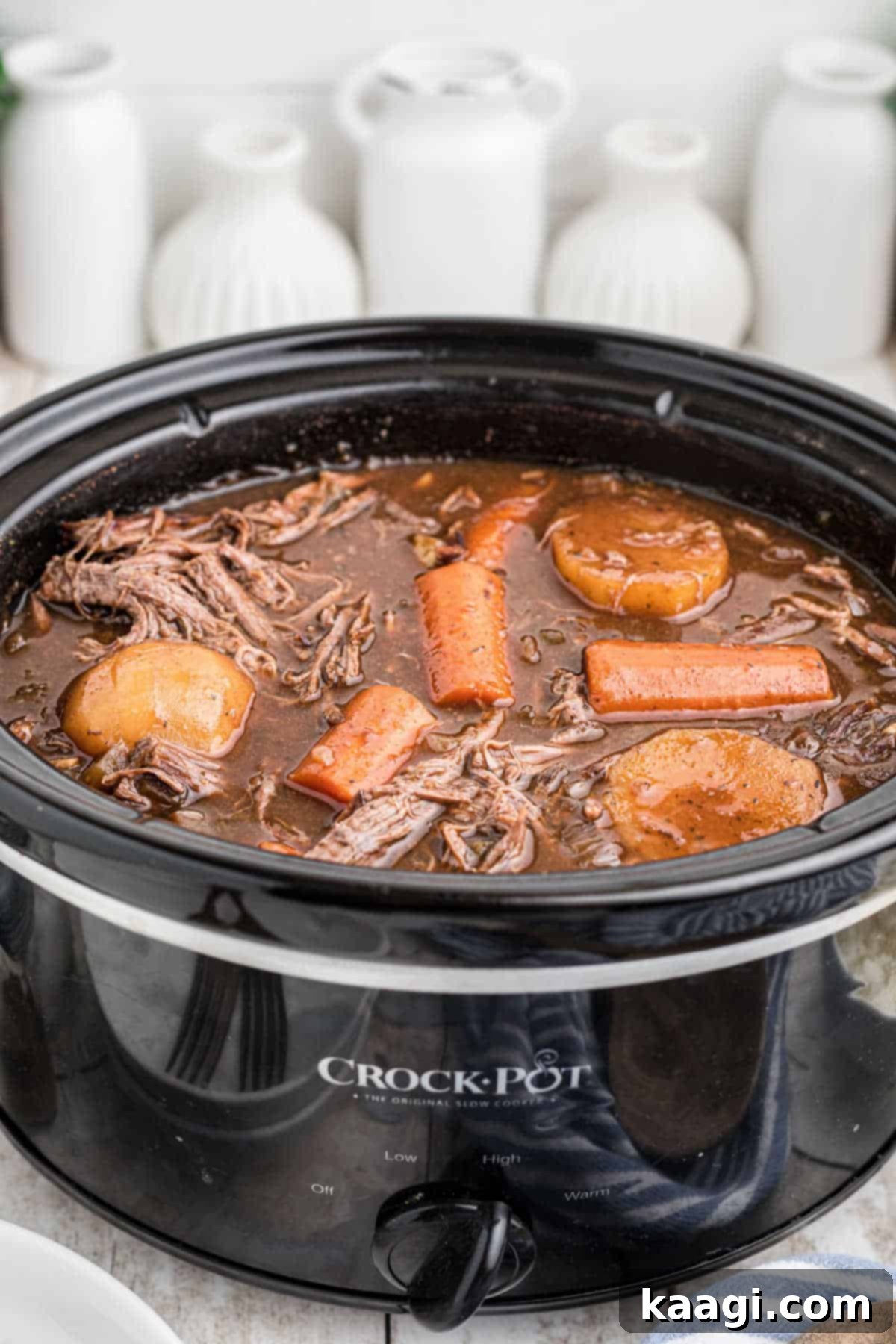 Red Wine Braised Venison Pot Roast 4 Front view of a slow cooker with venison roast with red wine.