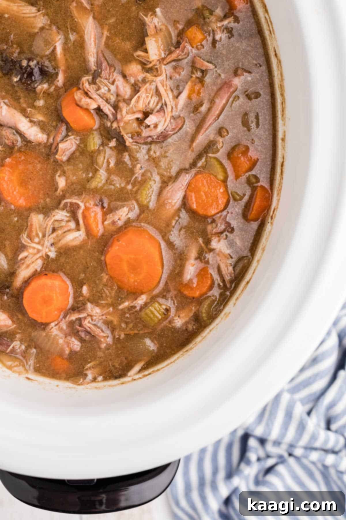 Tender Slow Cooker Rabbit Stew 2 Overhead close up of slow cooker rabbit stew with tender carrots and prunes, ready to be served.