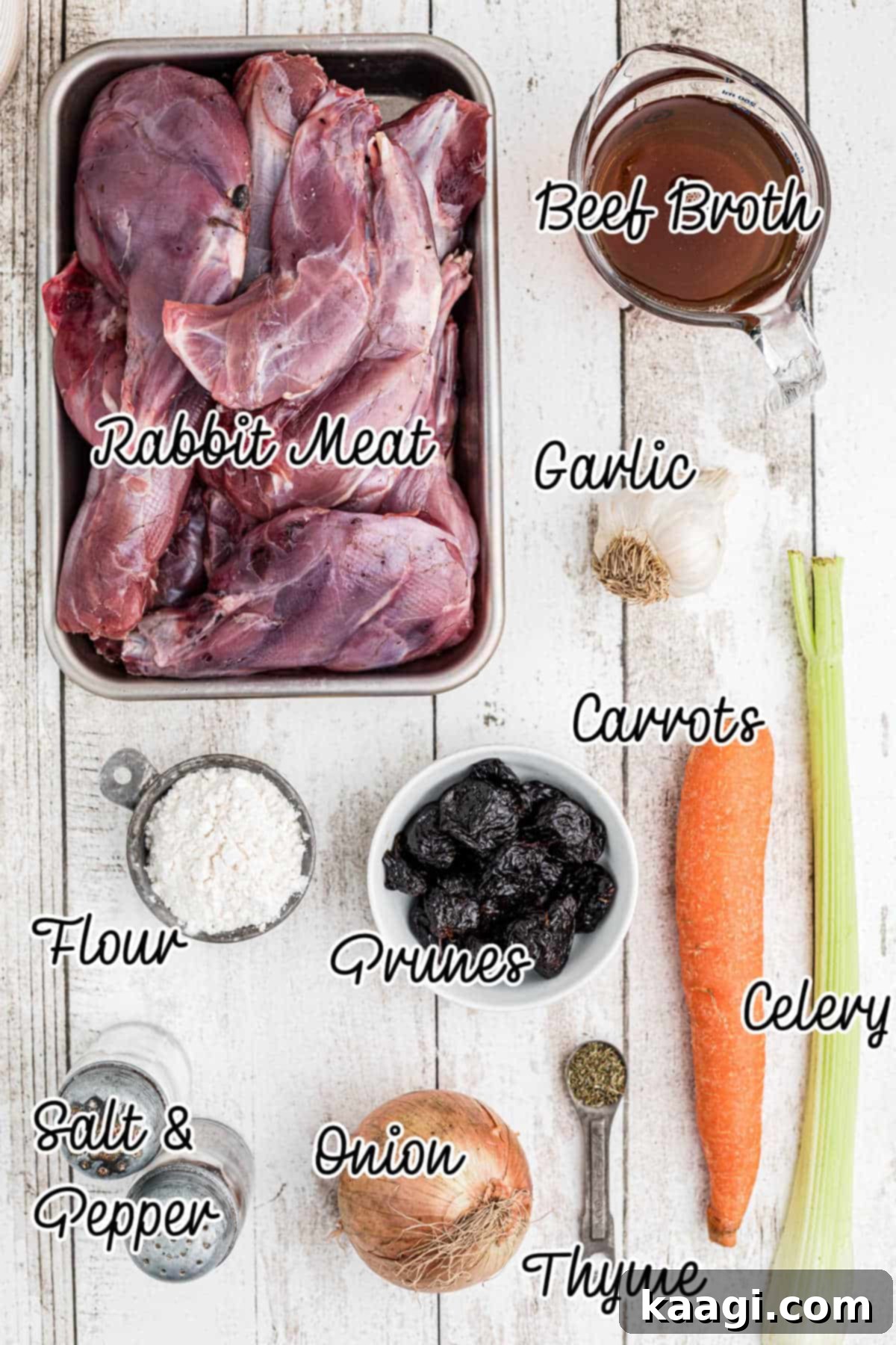 Tender Slow Cooker Rabbit Stew 3 Ingredients laid out on a rustic surface, including rabbit meat, carrots, onions, garlic, celery, prunes, dried thyme, flour, salt, pepper, olive oil, and beef broth, for making a slow cooker rabbit stew.