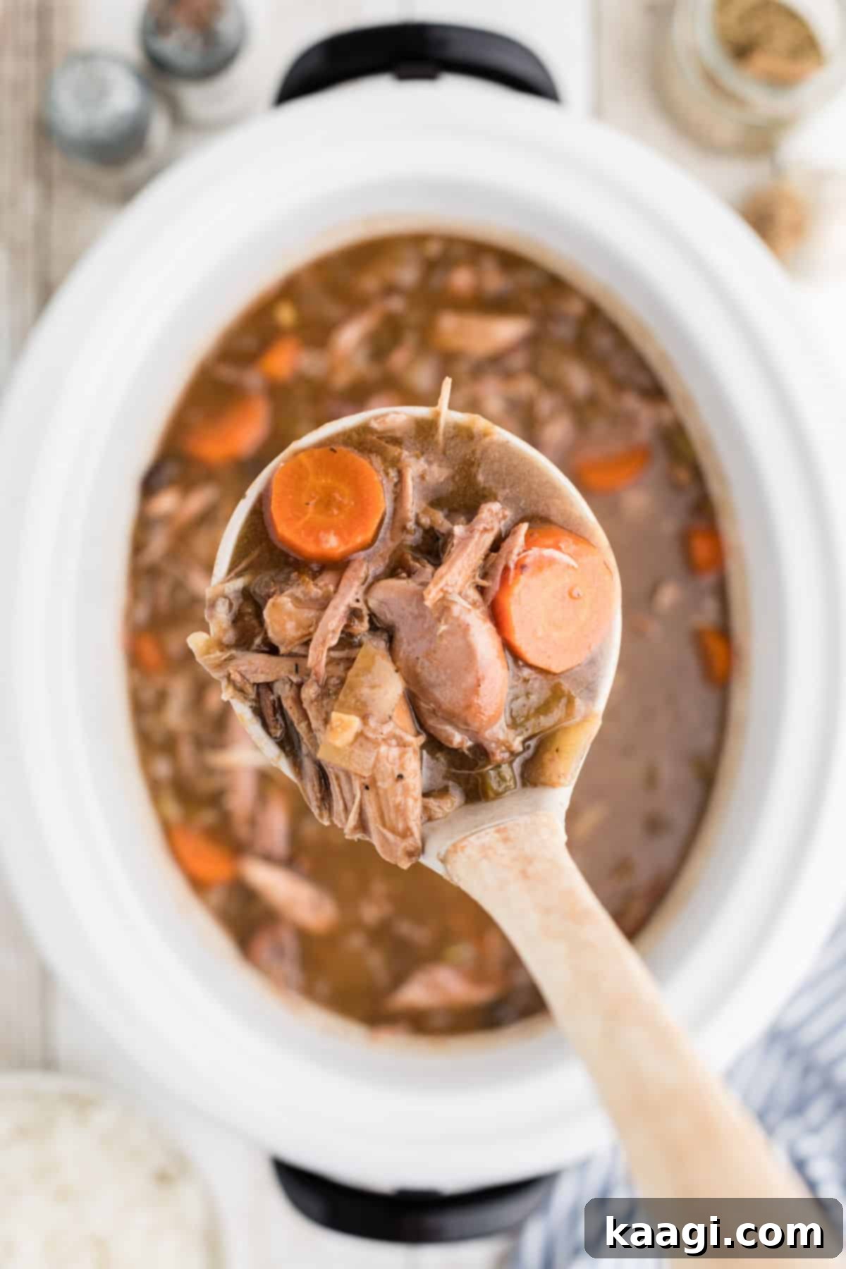 Tender Slow Cooker Rabbit Stew 5 A serving of slow cooker rabbit stew, with a ladle poised to serve, highlighting the rich broth and tender meat.