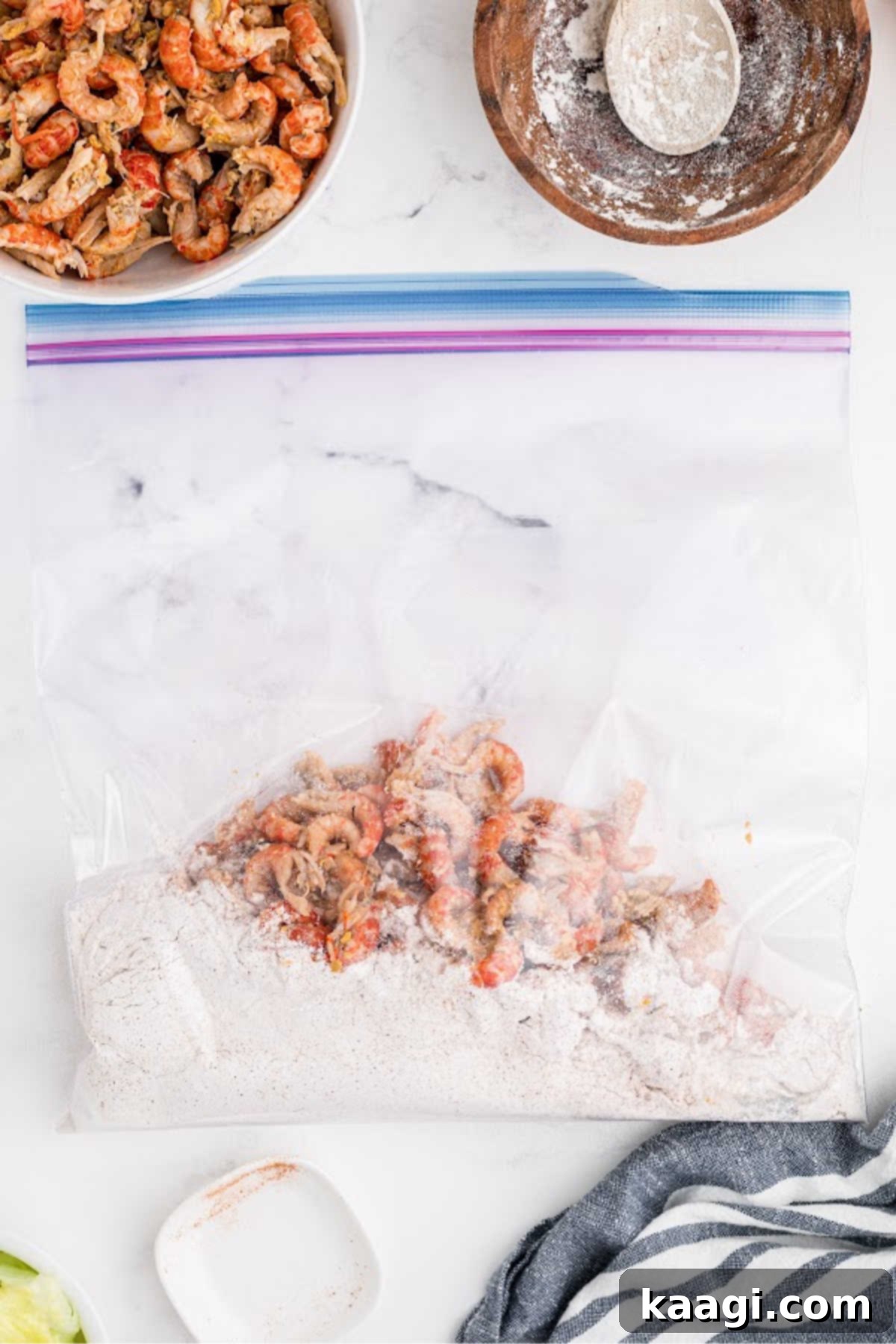 Peeled crawfish being added to a resealable bag filled with flour and seasonings.