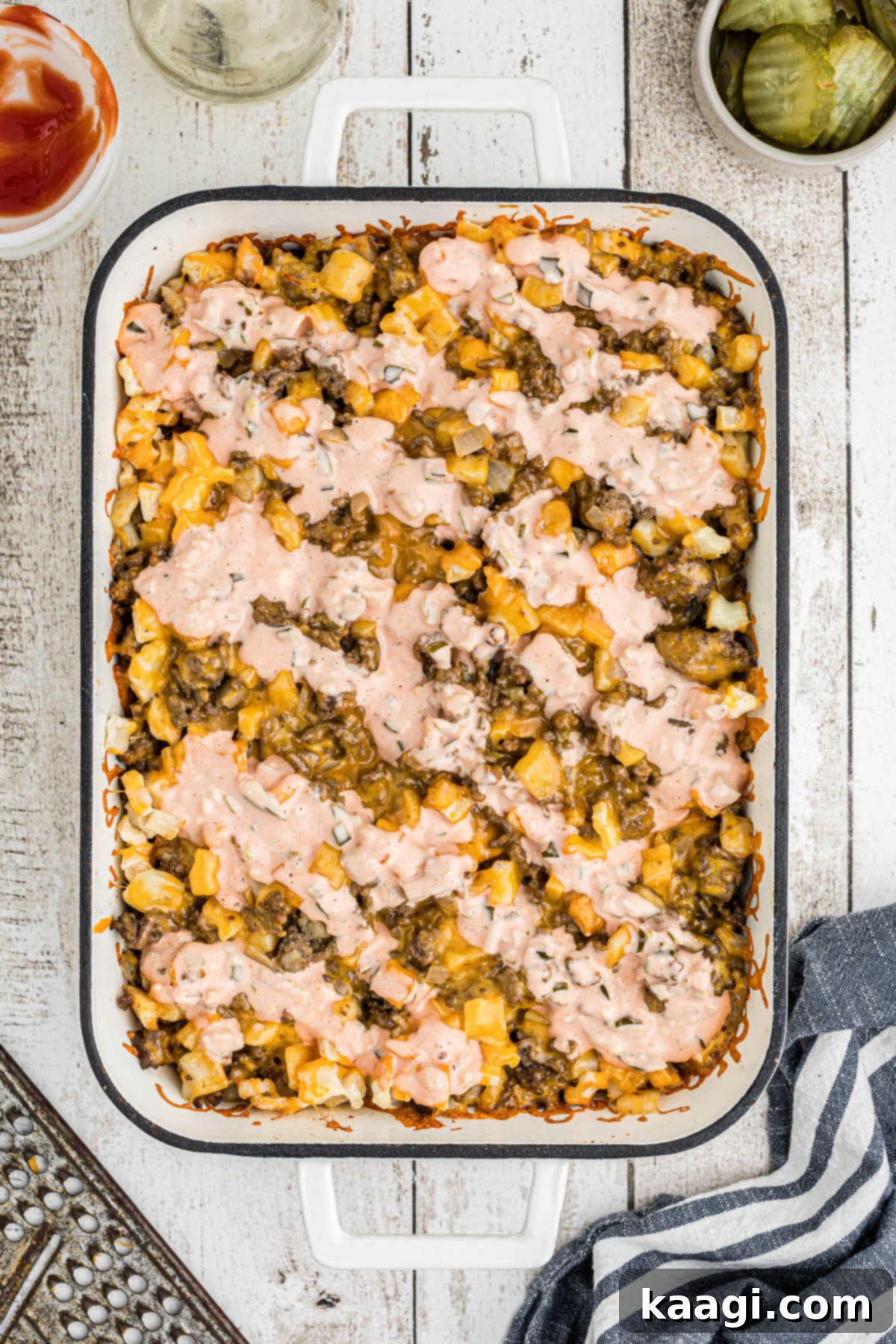 Ultimate Big Mac Comfort Casserole 11 An overhead view of a big mac casserole that has the sauce just been spread on top.