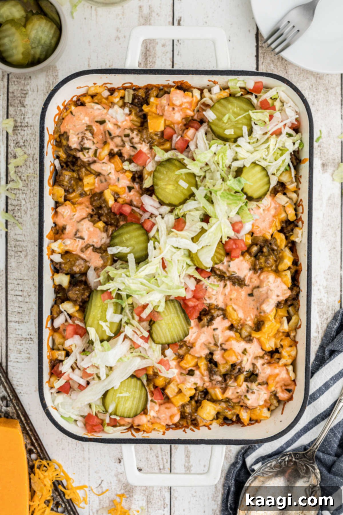 Ultimate Big Mac Comfort Casserole 12 An overhead shot of a Big Mac Casserole that has just been dressed with lettuce and pickles.