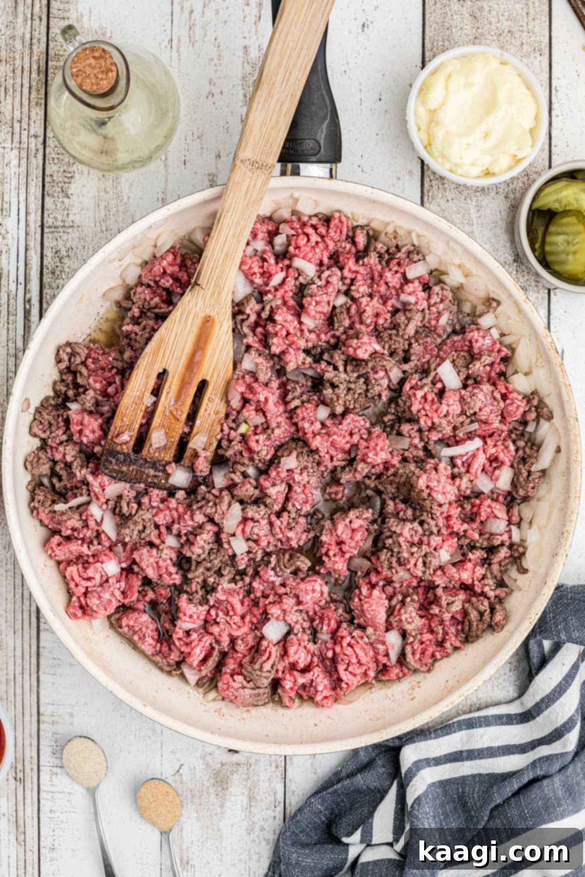 Ultimate Big Mac Comfort Casserole 5 An overhead view of a large skillet filled with ground meat cooking with onions.