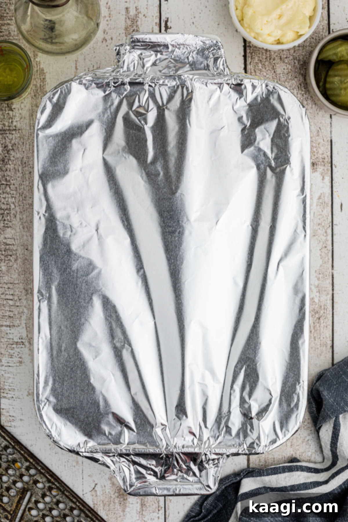 Ultimate Big Mac Comfort Casserole 9 An overhead view of a casserole dish that has been covered with foil.
