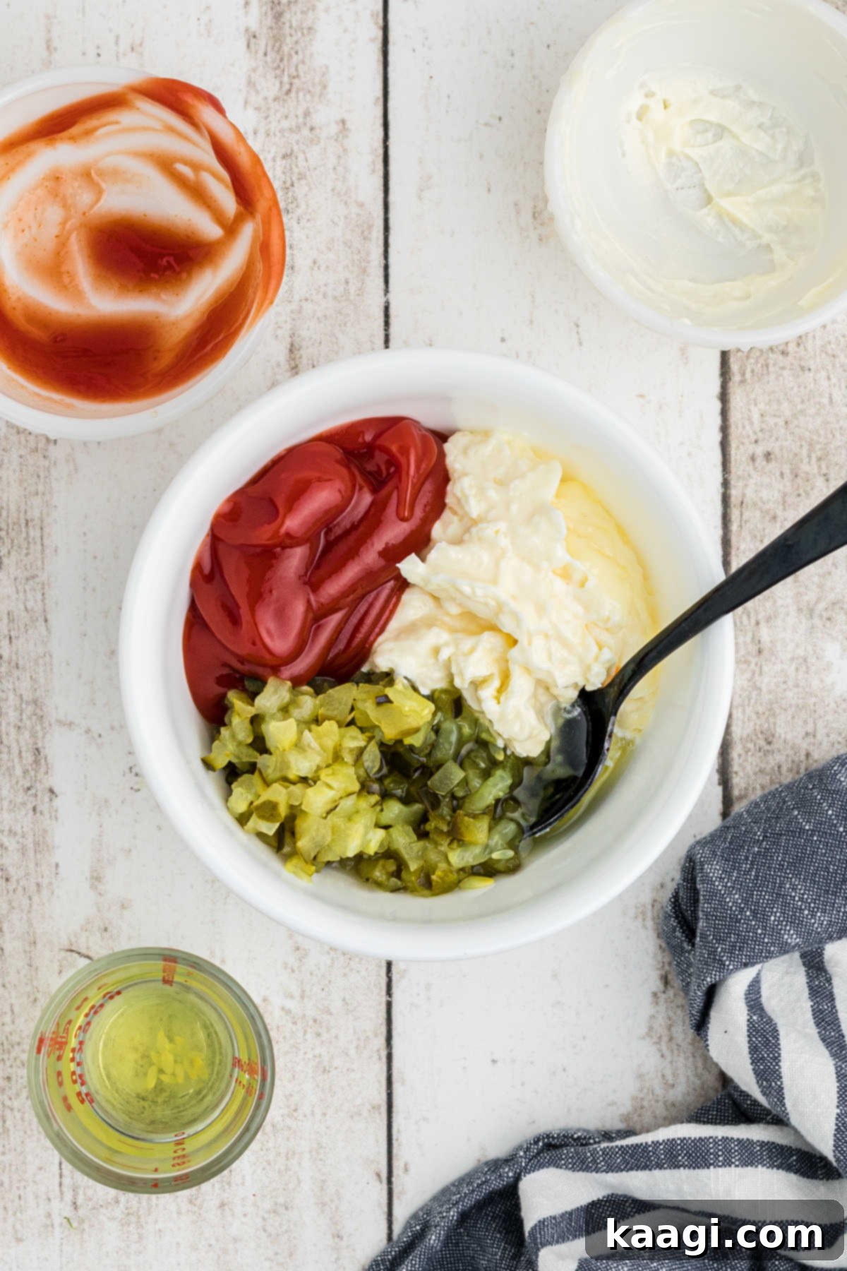 Ultimate Big Mac Comfort Casserole 10 A small bowl filled with ketchup, mayonnaise and pickles, about to be mixed together with a spoon.