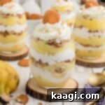 Some individual banana pudding cups sitting on top of wooden coasters, ready to be served.