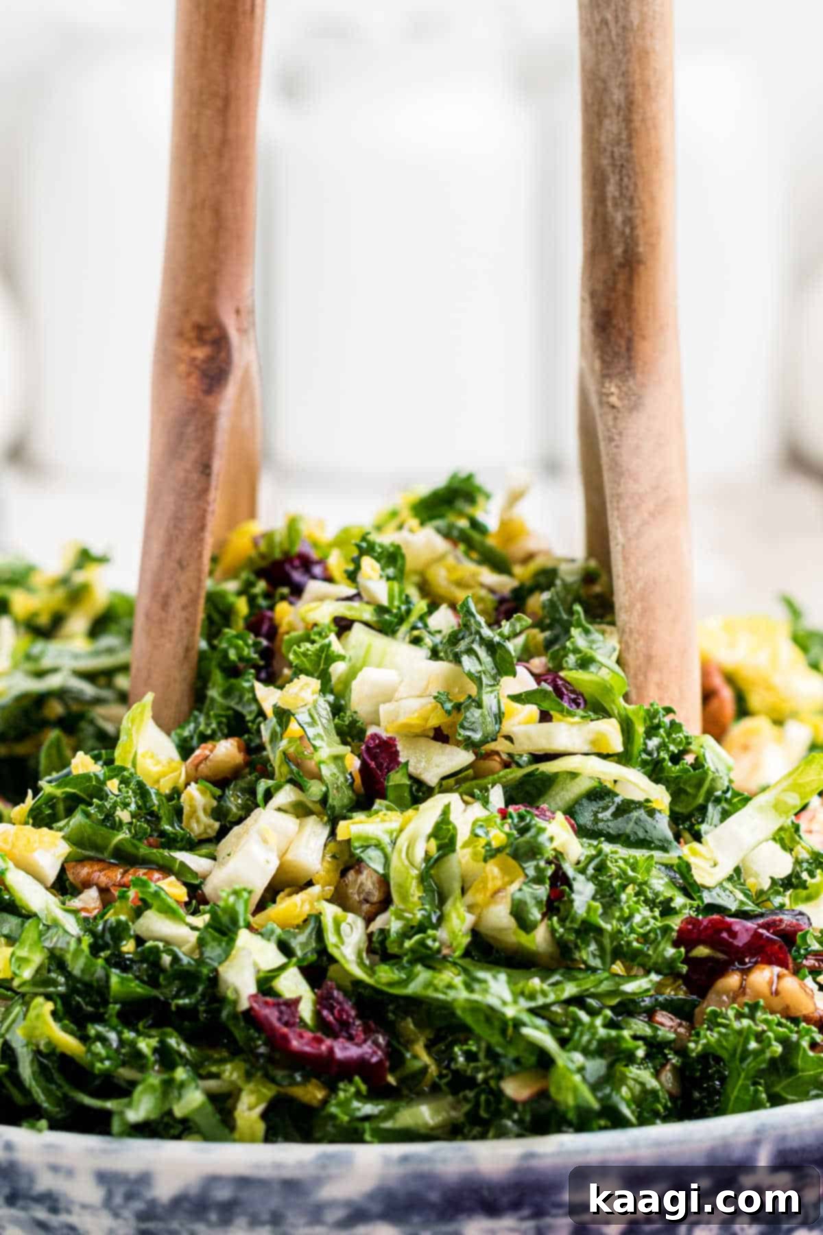 Copycat Cracker Barrel Kale Salad 6 Close up of a cracker barrel kale salad with a fork and spoon digging in.