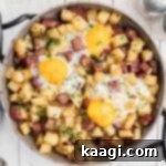 Overhead and cropped square, a skillet with a traditional Irish corned beef hash recipe, highlighting its golden crust and delicious texture.