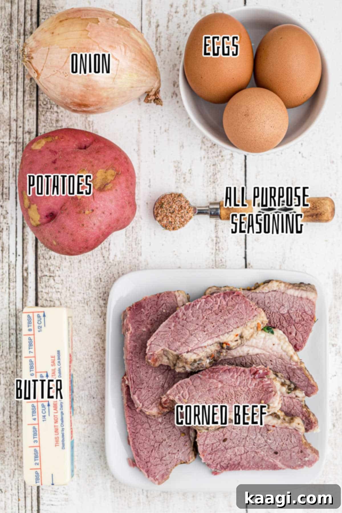 Overhead shot of ingredients needed to make a traditional Irish corned beef hash recipe, including potatoes, onions, corned beef, butter, seasoning, and eggs.