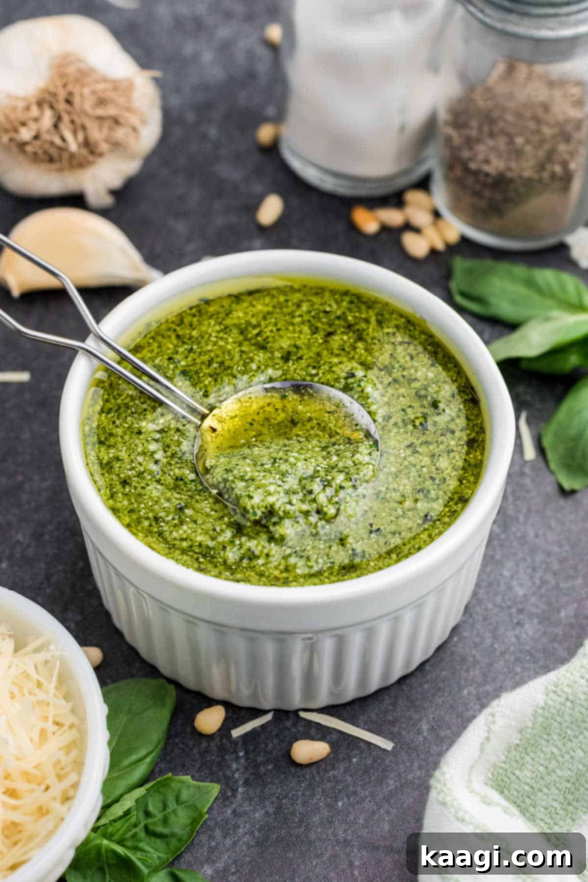 Vibrant Pesto Vinaigrette 2 A small bowl of vibrant green pesto dressing with a spoon digging in, ready to be served.