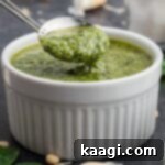 Vibrant Pesto Vinaigrette 8 Close up of a bowl of pesto dressing with a spoon digging in.