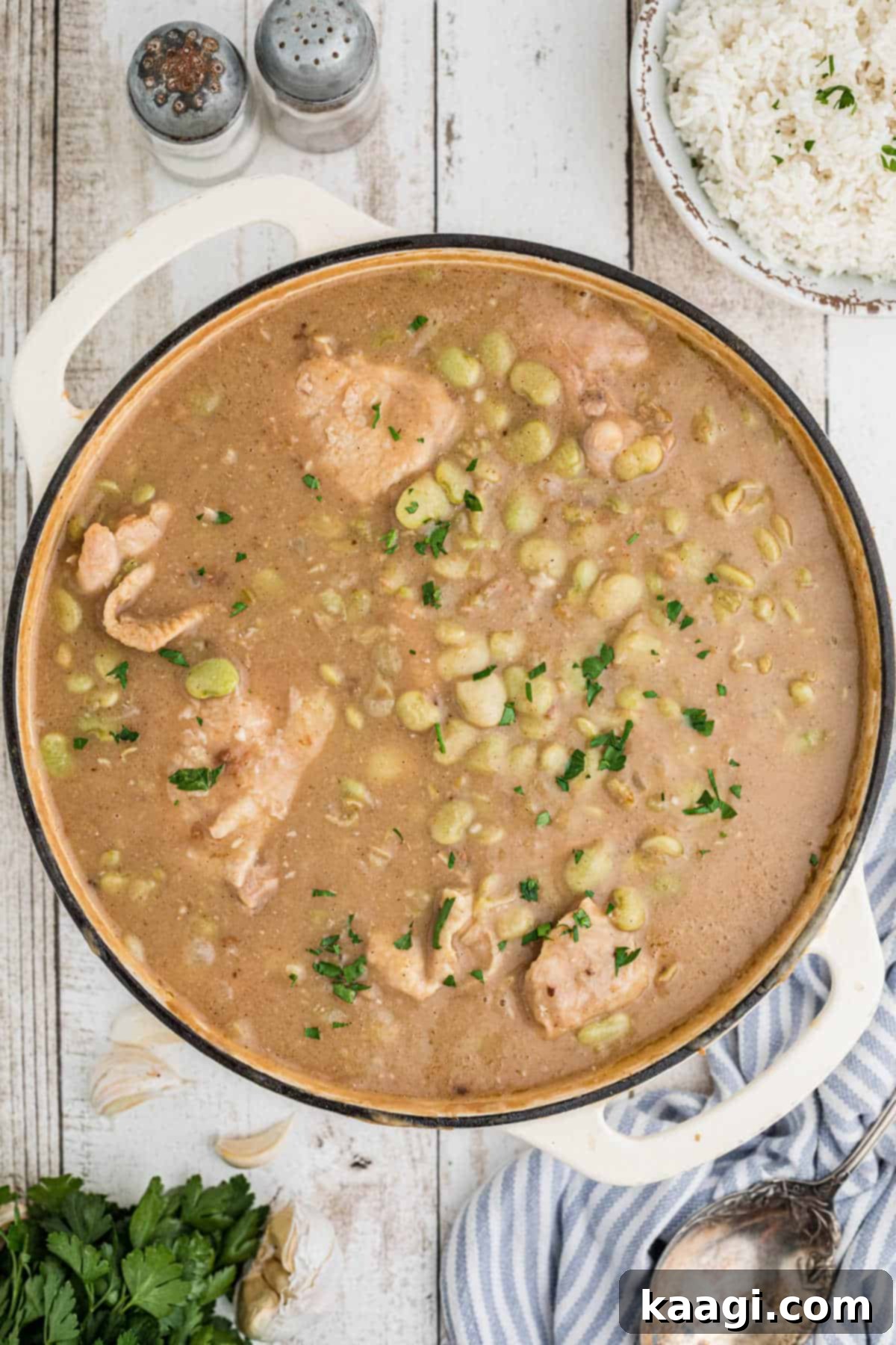 Overhead shot of a pot full of chicken and lima beans, rich and inviting.