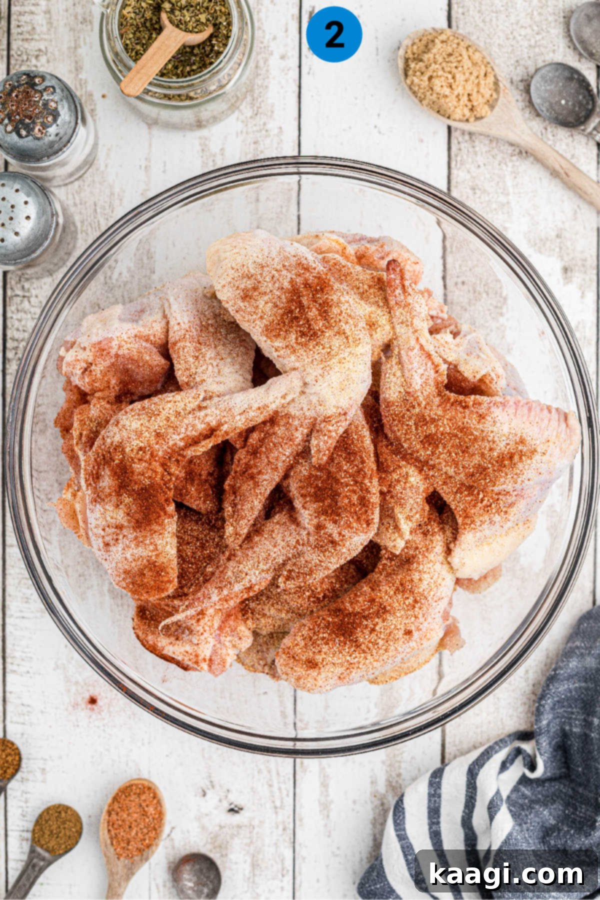 Homemade Wingstop Louisiana Rub 5 Chicken wings in a bowl with a generous sprinkle of initial seasoning on top.