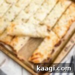 Square shot of an Italian cheese bread with one piece taken out, showcasing its delicious texture.