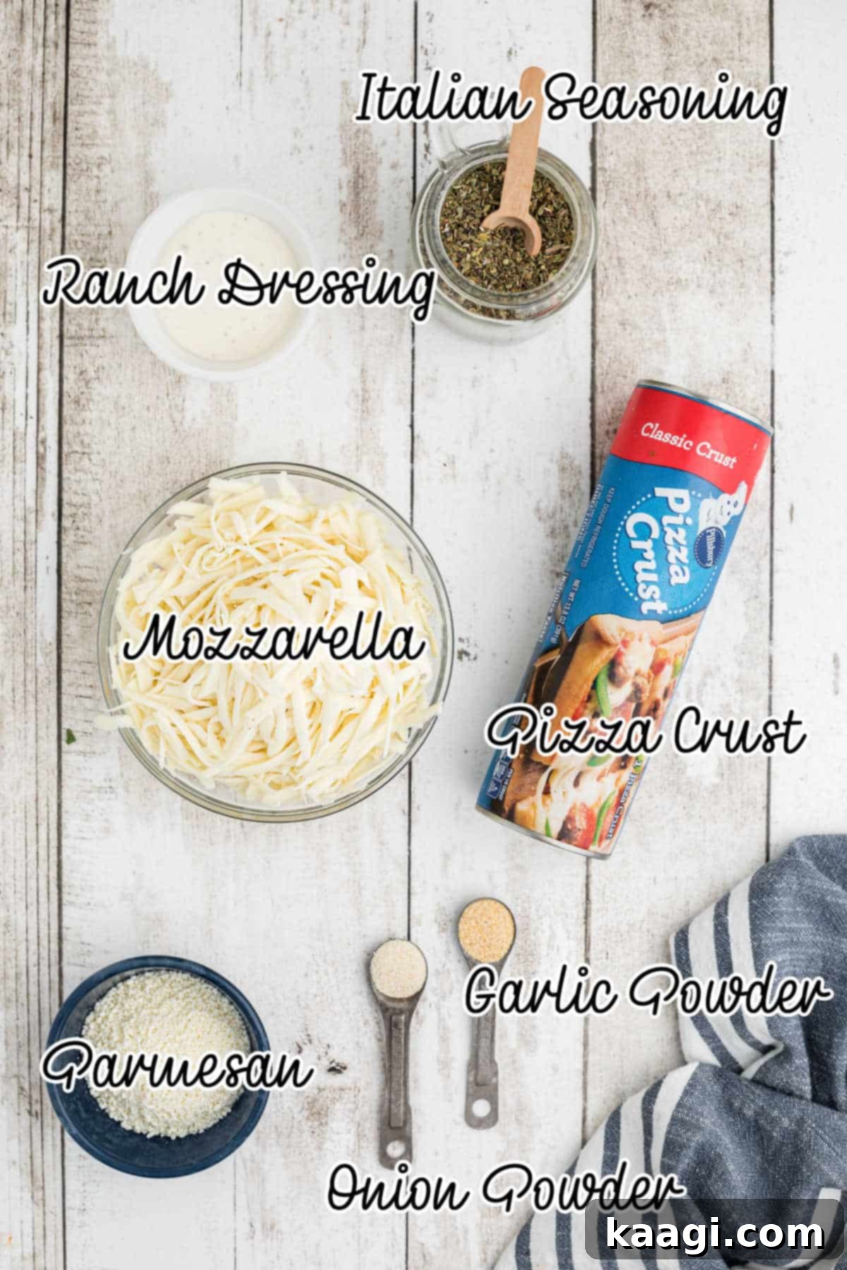 A flat lay photograph displaying all the simple ingredients required to make easy Italian Cheese Bread, including pizza dough, cheeses, and seasonings.