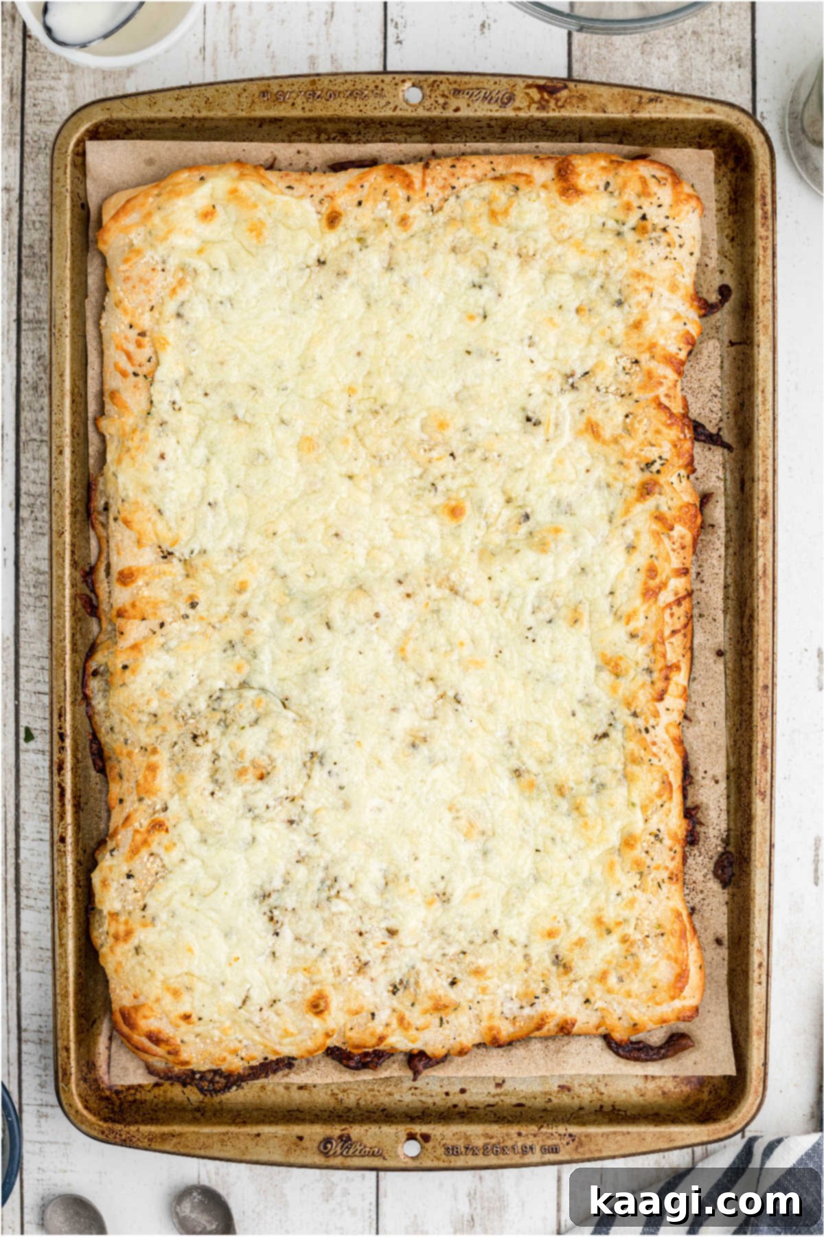 A golden-brown, baked Italian cheese bread fresh out of the oven, with perfectly melted and bubbly cheese, showcasing its readiness.