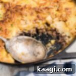 Close up of a hobo casserole in a skillet with a spoon, ready to serve.