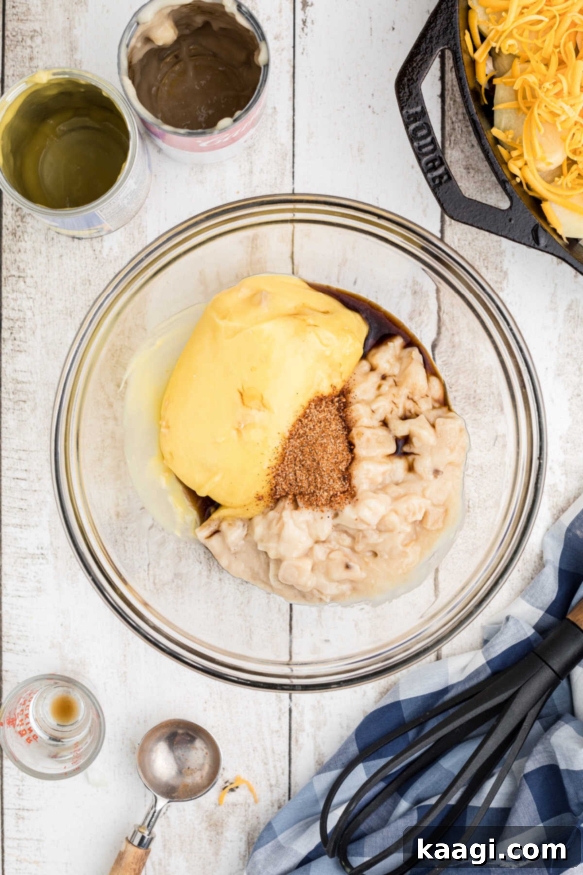 Overhead shot of a mixing bowl, with cream soups, Worcestershire sauce, milk, and Creole seasoning ready to be mixed together.