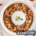 An overhead shot of a bowl of crawfish stew with a heap of white rice in the middle.