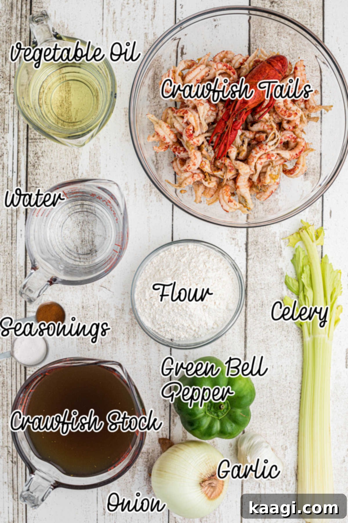 A selection of fresh ingredients laid out, including vegetable oil, flour, diced yellow onions, green bell peppers, celery, garlic cloves, and a container of crawfish stock.