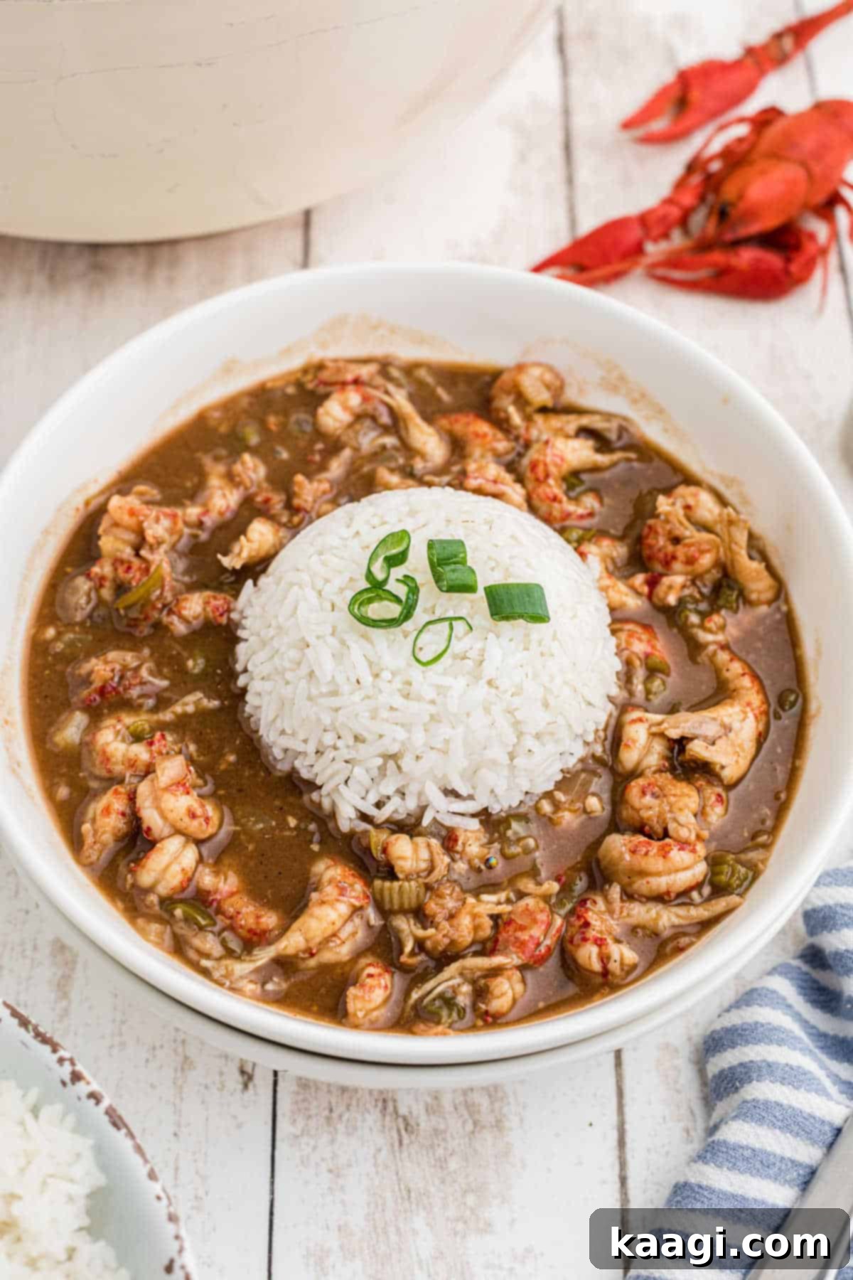 A close-up shot of a bowl of delicious crawfish stew with a generous portion of white rice in the center, ready to be enjoyed.