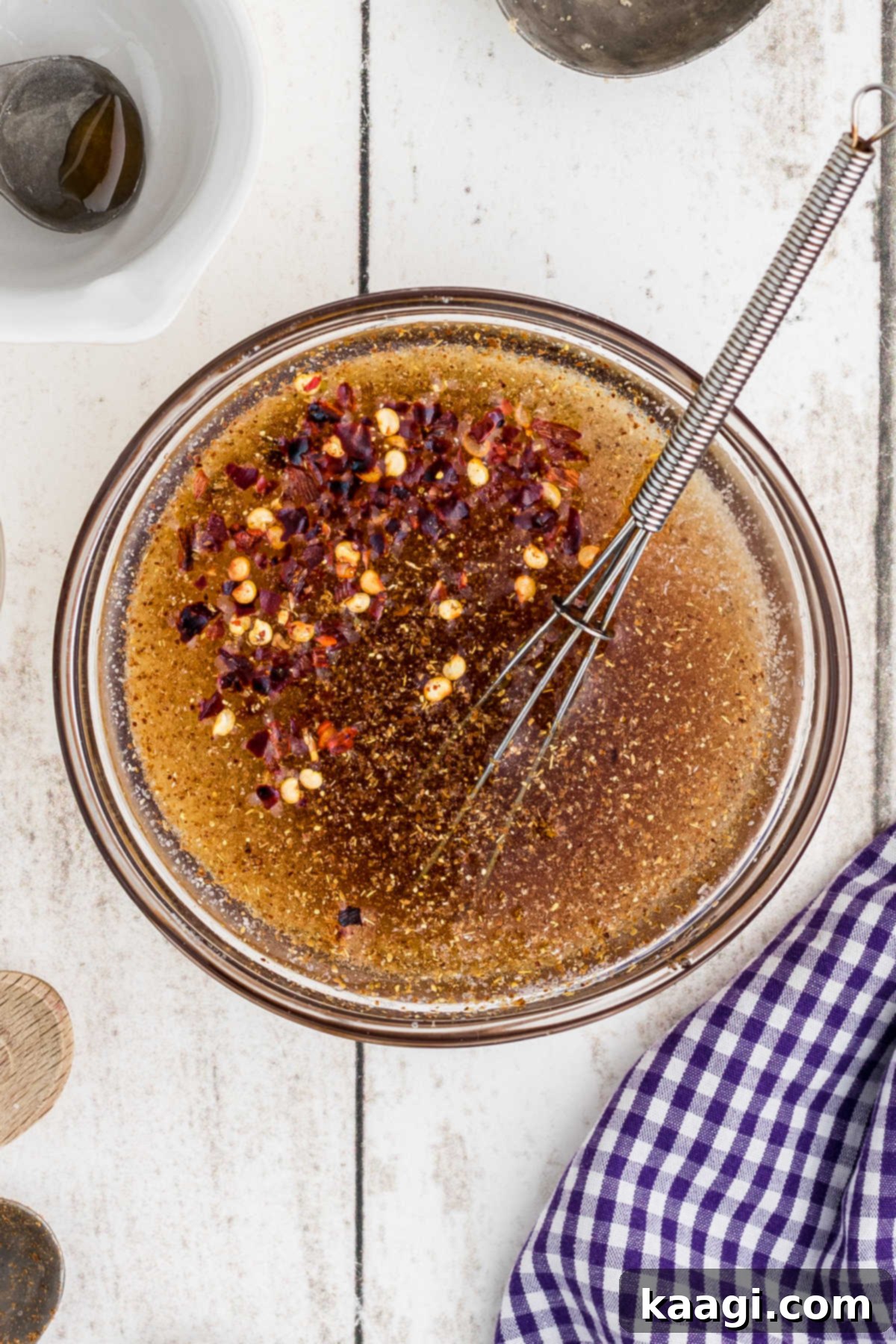 Overhead shot of a small bowl with seasonings, honey, and jam being mixed for a popeyes sweet heat sauce recipe.