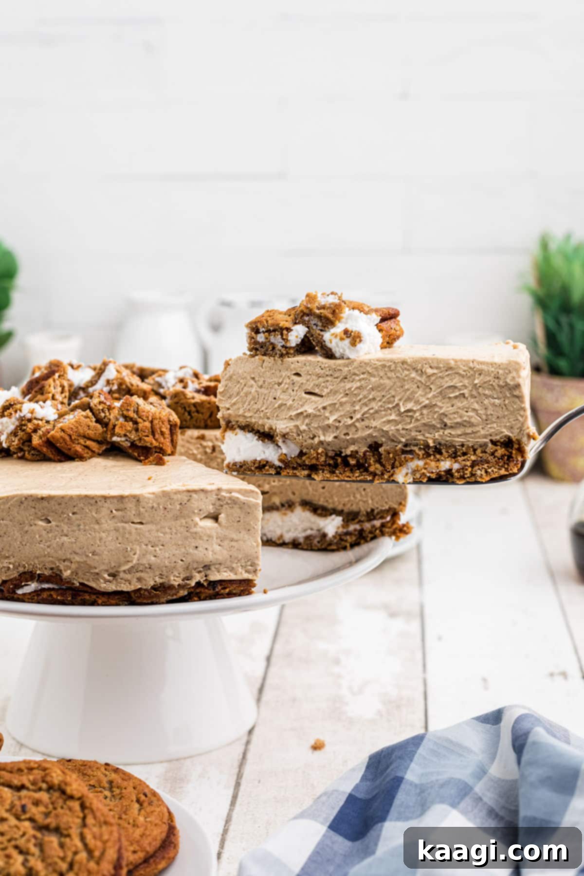 A glorious slice of oatmeal creme pie cheesecake being carefully lifted out of the whole cake, showcasing its layers.