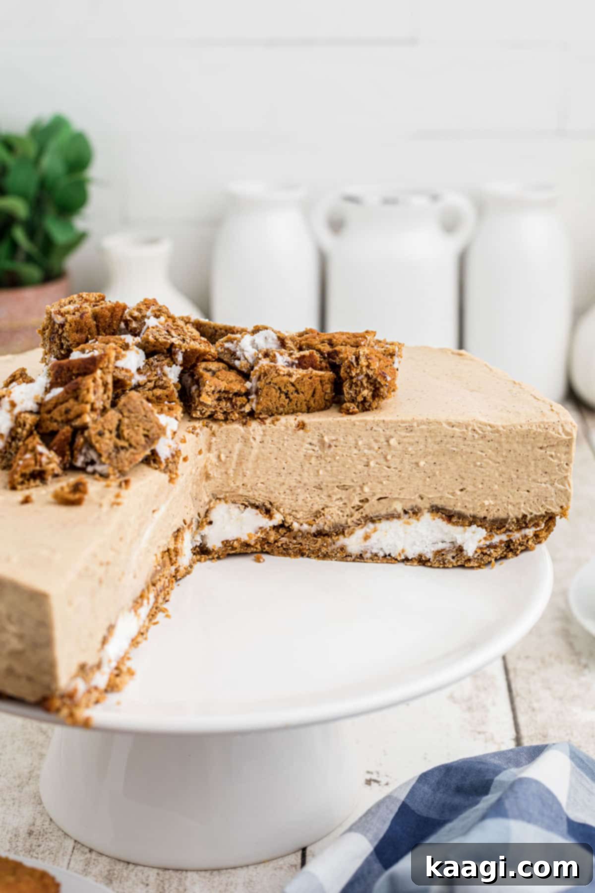 A cake stand showcasing a perfectly set oatmeal creme pie cheesecake with several slices already removed, ready for serving.