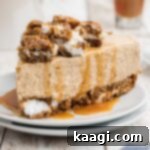 A slice of oatmeal creme pie cheesecake with caramel sauce drizzled on top.