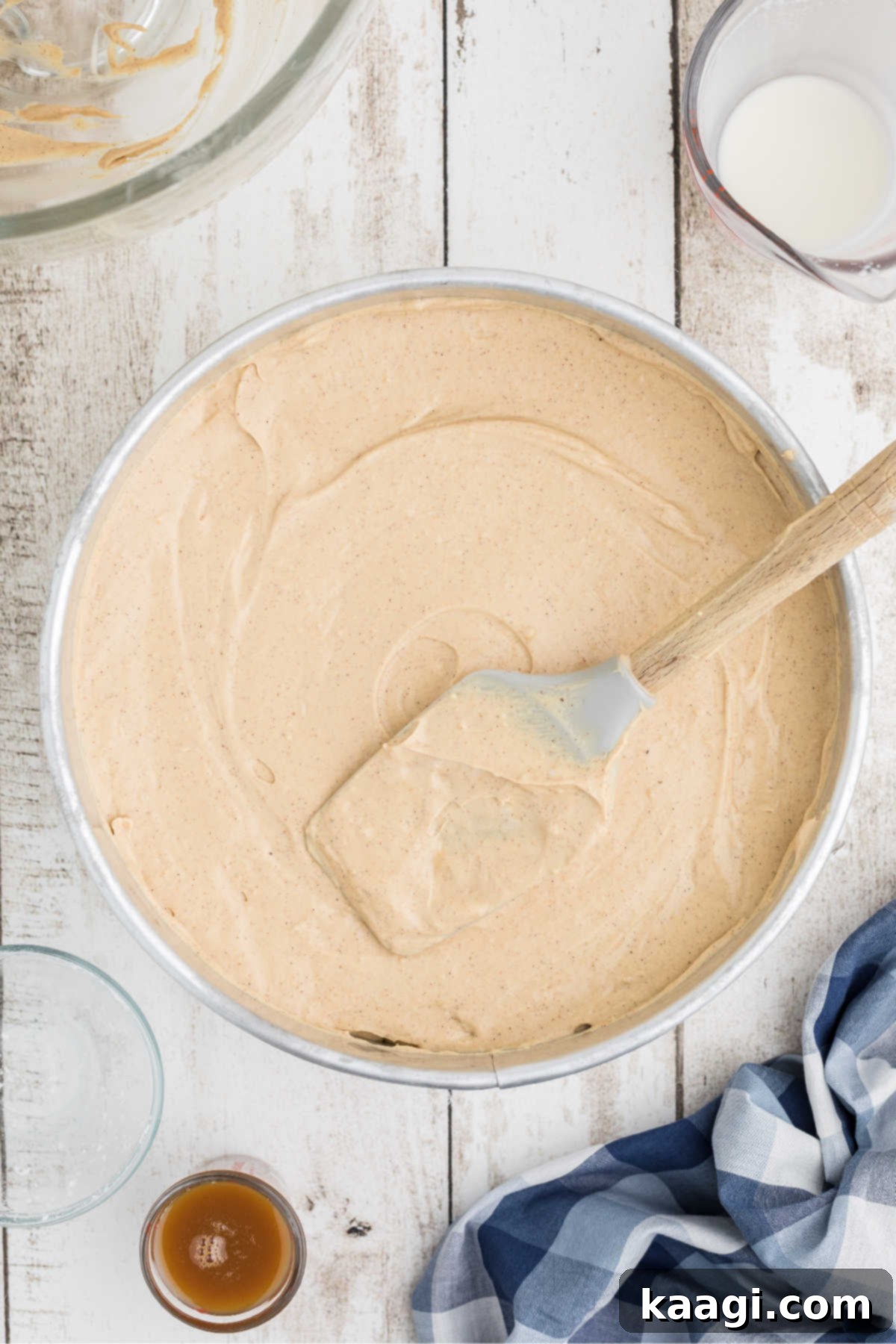 A cheesecake being smoothed out with the back of a spatula for an even surface.
