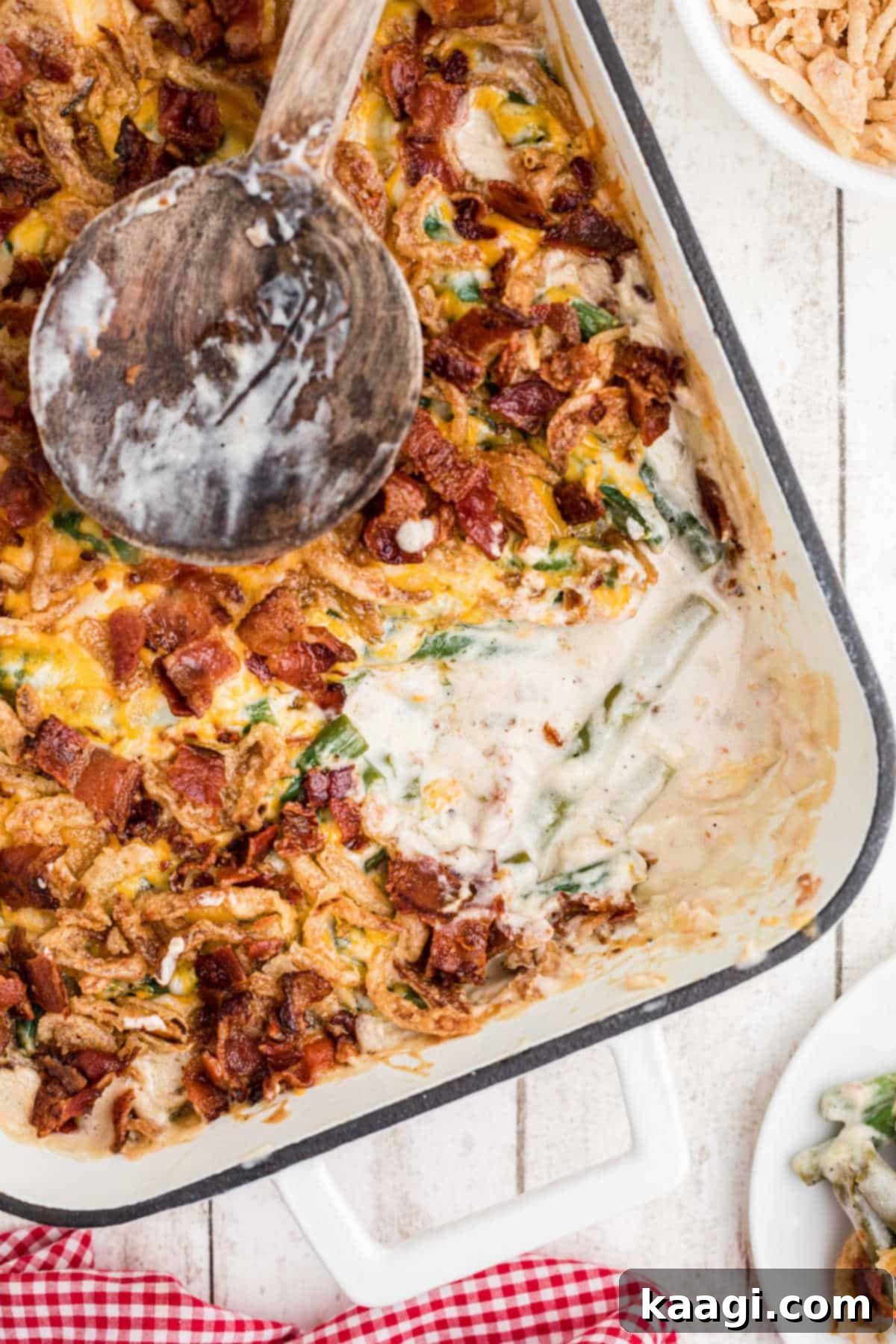 Overhead shot of a casserole dish with loaded green bean casserole in it, a scoop missing.