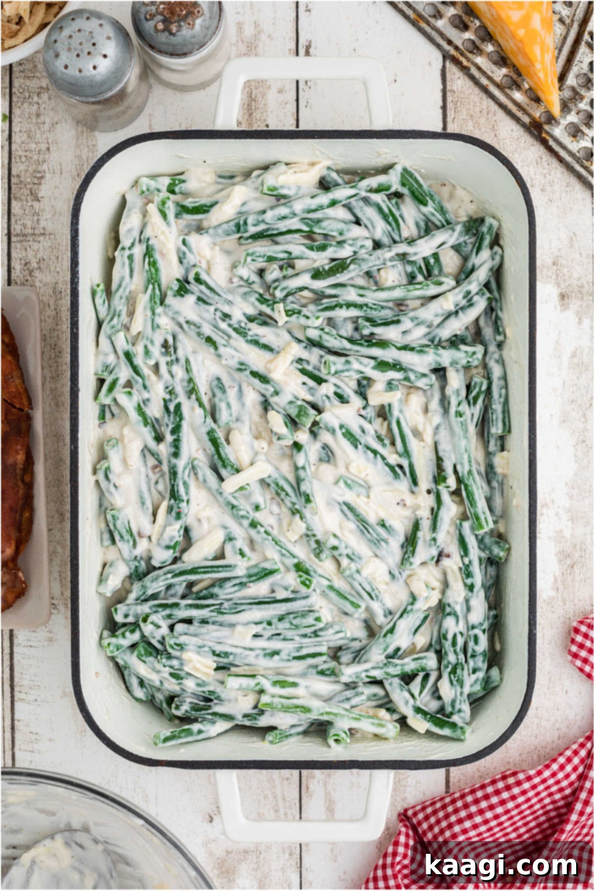 A baking dish filled with green beans and sauce waiting to be baked.