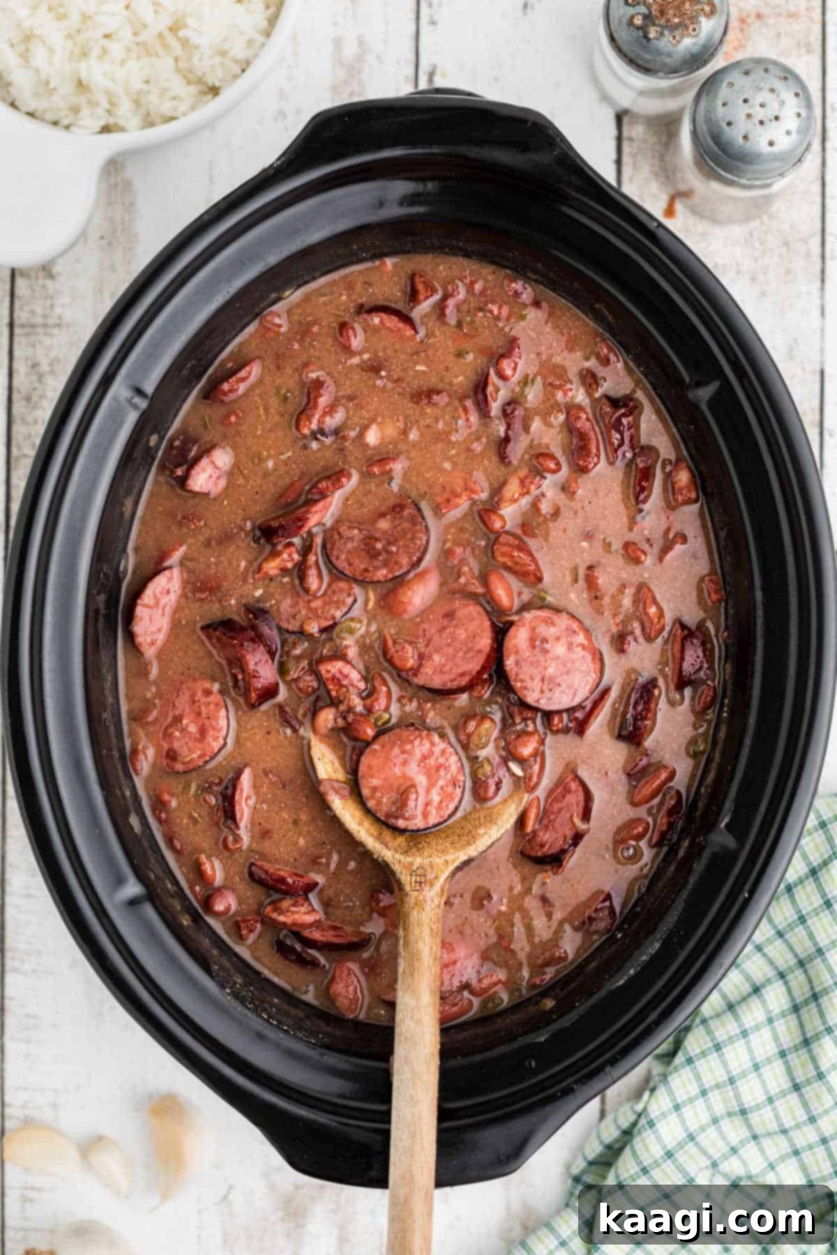 Soulful Slow Cooker Cajun Red Beans and Rice 2 A spoon resting in a slow cooker with red beans and rice.